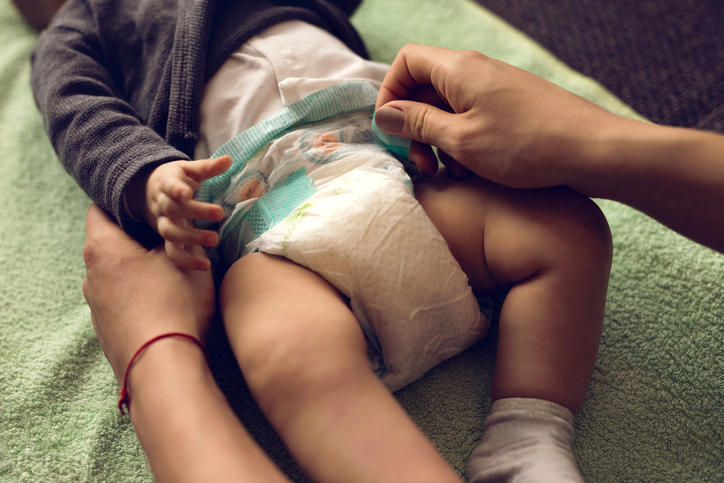 Close-up of a mother changing diapers to her baby boy.