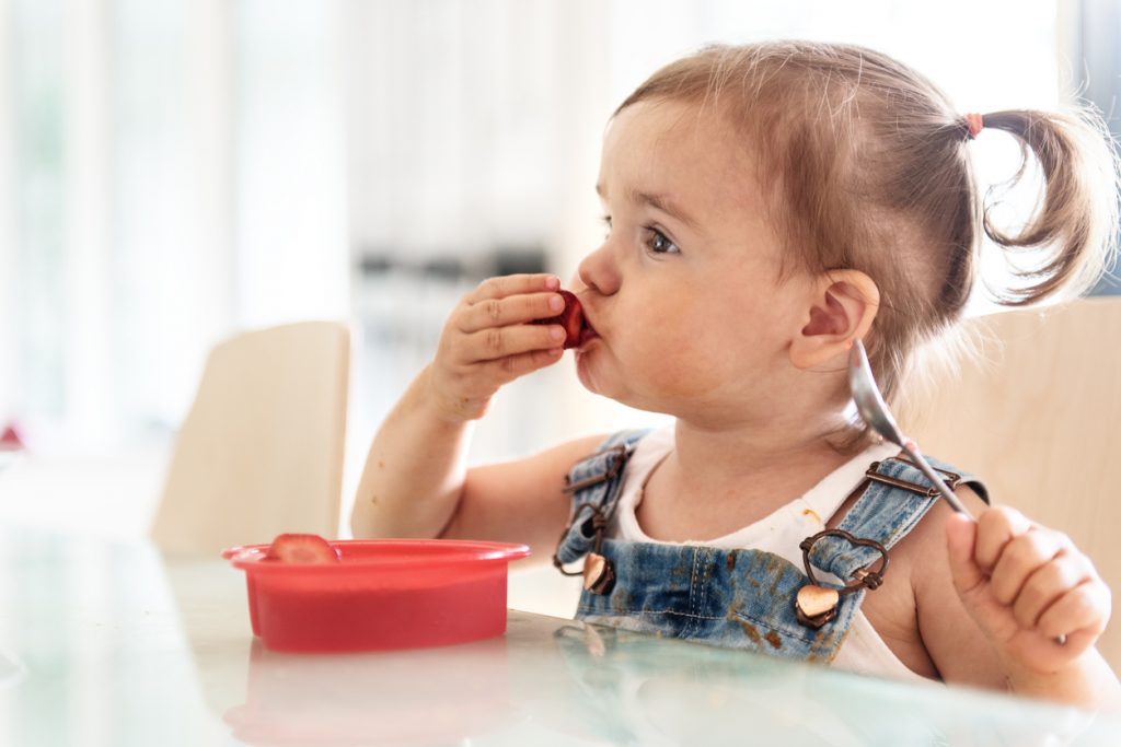 Little 2 years old girl eating jello