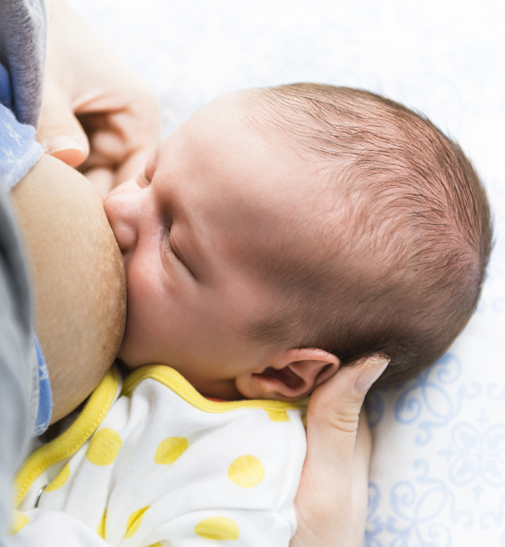 Breastfeeding a cute newborn baby boy.